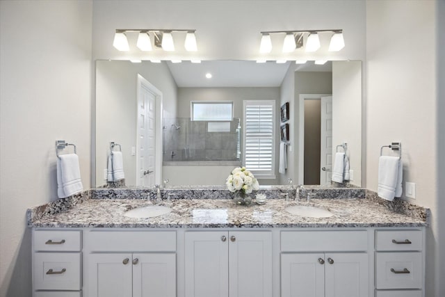 bathroom featuring a tile shower and vanity