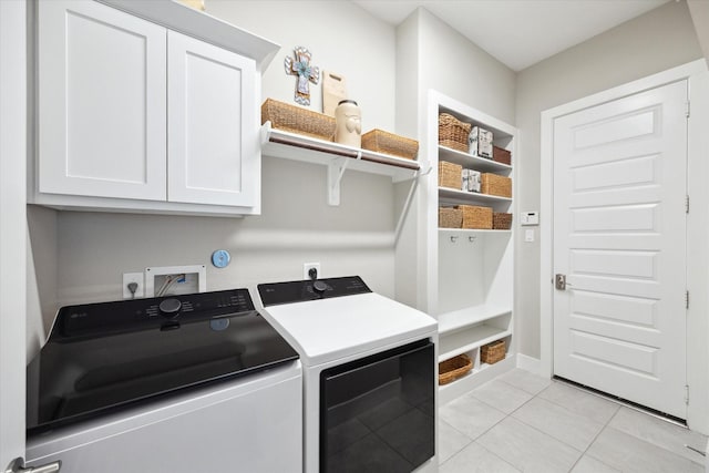 laundry room with cabinets, washer and dryer, and light tile patterned floors