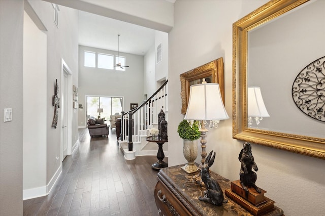 foyer entrance with dark hardwood / wood-style floors and a high ceiling