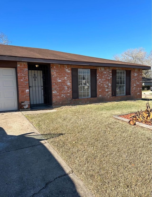 ranch-style house with a garage and a front lawn