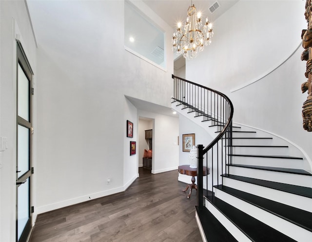 foyer entrance with baseboards, visible vents, a towering ceiling, stairway, and dark wood-style flooring