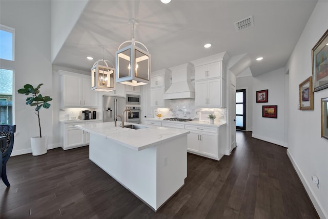 kitchen with premium range hood, decorative light fixtures, and white cabinets