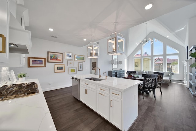 kitchen with light stone countertops, appliances with stainless steel finishes, a sink, and decorative light fixtures