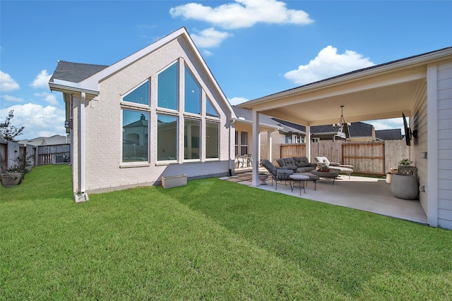 rear view of property with a patio, fence, a yard, outdoor lounge area, and brick siding