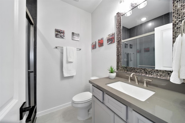 full bathroom featuring toilet, a stall shower, baseboards, and vanity