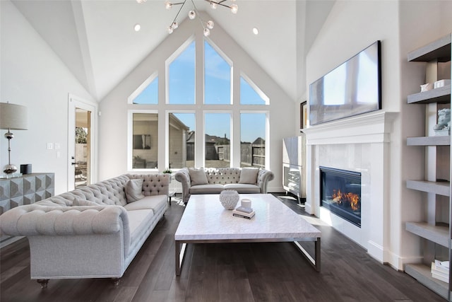 living room featuring dark wood-type flooring, a glass covered fireplace, high vaulted ceiling, and recessed lighting