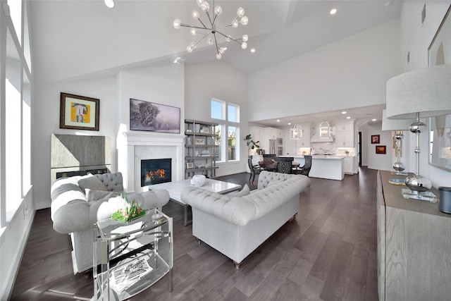 living room featuring a chandelier, a premium fireplace, dark wood-style floors, and recessed lighting