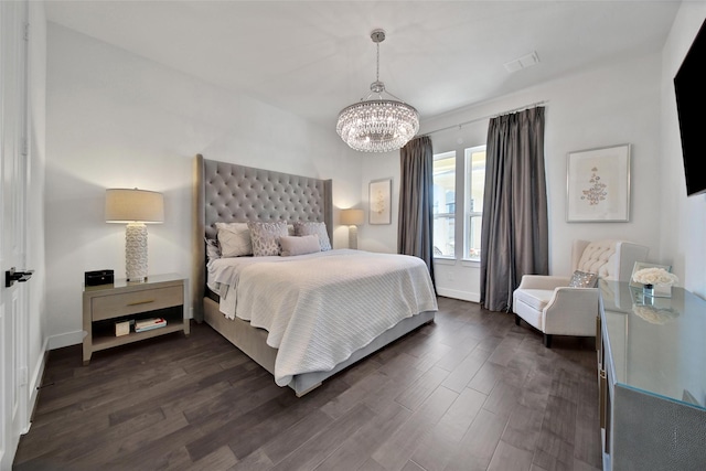 bedroom featuring baseboards, dark wood finished floors, visible vents, and a notable chandelier