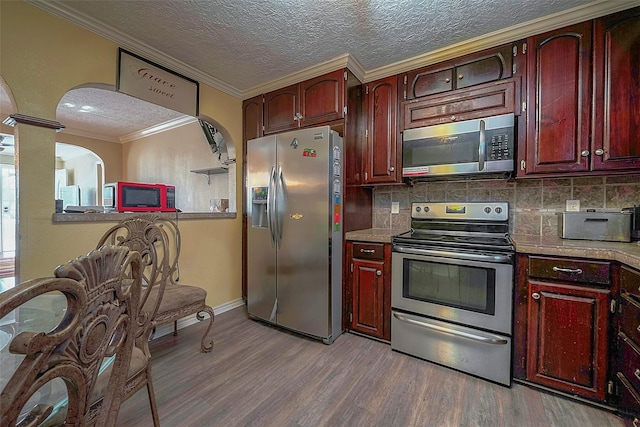 1814 Mansfield St, Houston, TX 77091 - kitchen featuring ornamental molding, appliances with stainless steel finishes, light hardwood / wood-style flooring, and backsplash