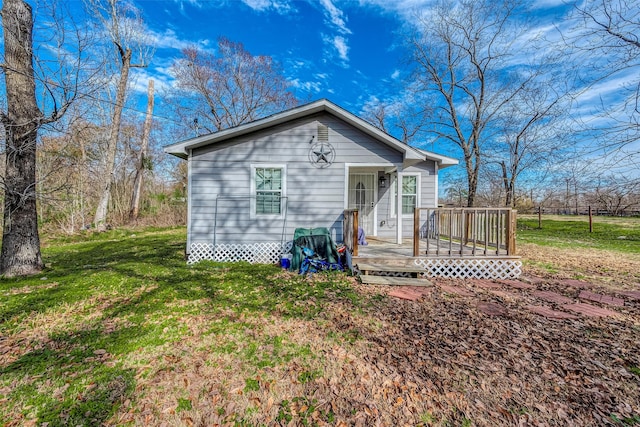 view of front facade with a wooden deck and a front lawn