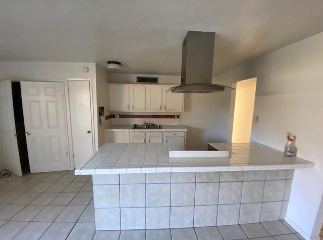 4846 Court Rd, Houston, TX 77053 - kitchen featuring tile countertops, sink, white cabinets, island exhaust hood, and kitchen peninsula