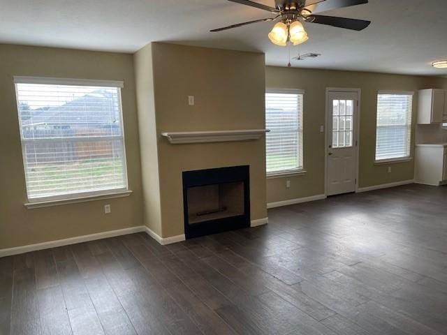 unfurnished living room featuring ceiling fan and dark hardwood / wood-style floors