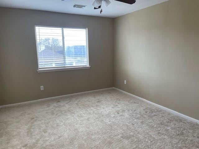 unfurnished room with light colored carpet and ceiling fan