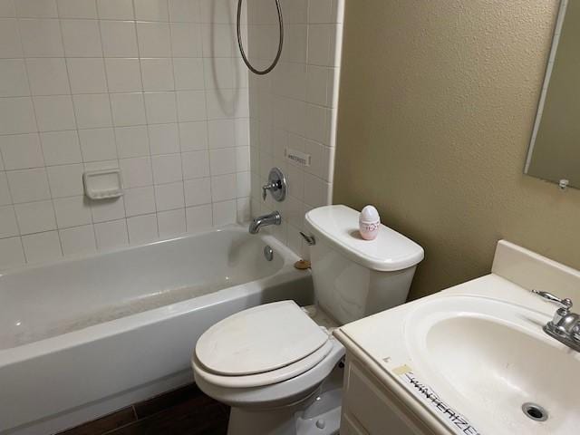 full bathroom featuring tiled shower / bath, wood-type flooring, vanity, and toilet