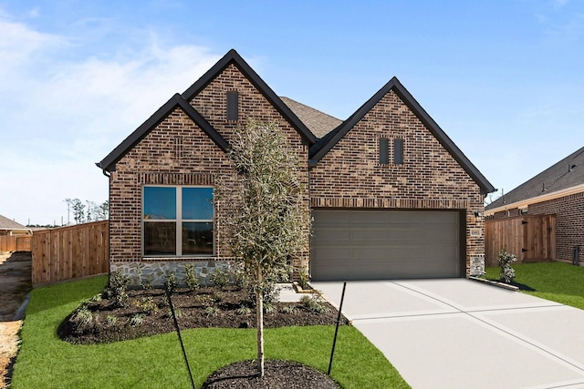 view of front of property featuring brick siding, fence, concrete driveway, a front yard, and a garage