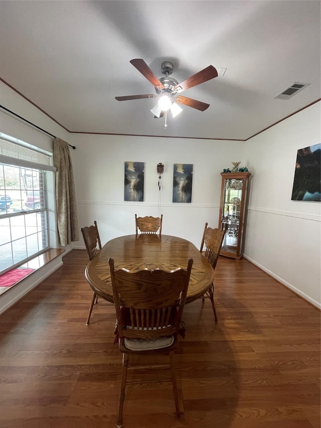 dining space featuring a ceiling fan, visible vents, and dark wood finished floors