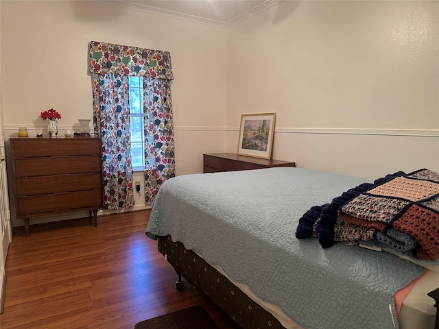 bedroom featuring crown molding and wood finished floors