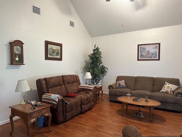 living area with ceiling fan, wood finished floors, visible vents, and baseboards