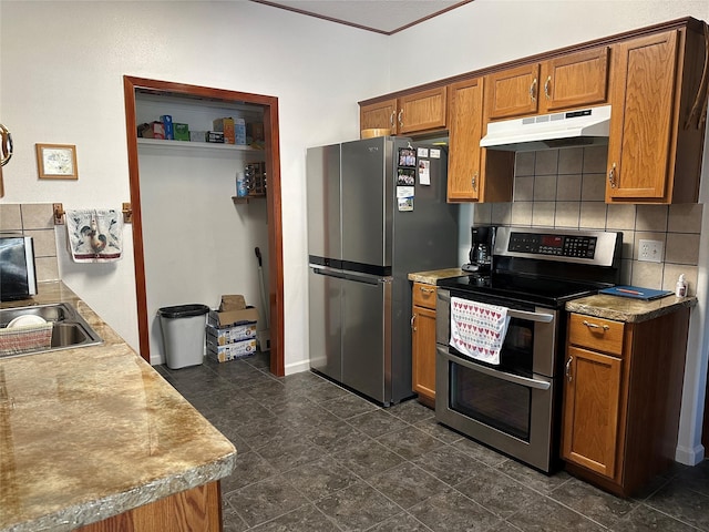 kitchen featuring decorative backsplash, brown cabinets, stainless steel appliances, light countertops, and under cabinet range hood