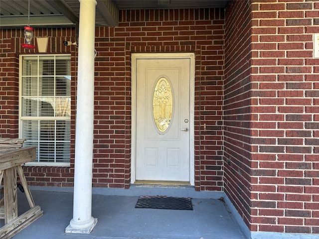 doorway to property featuring brick siding