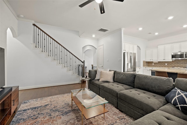 living room featuring crown molding, dark wood-type flooring, and ceiling fan