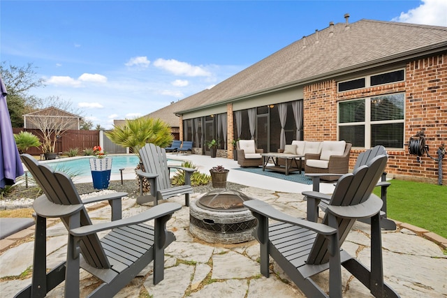 view of patio with a fenced in pool and an outdoor living space with a fire pit