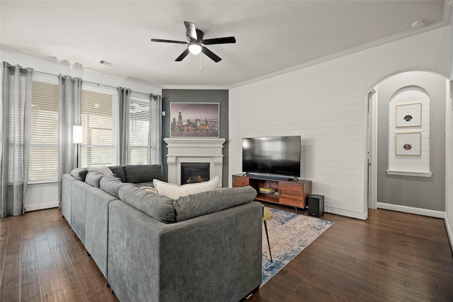 living room featuring crown molding, ceiling fan, and dark hardwood / wood-style floors