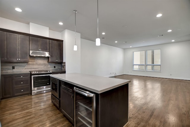 kitchen with decorative light fixtures, beverage cooler, backsplash, a center island, and stainless steel appliances