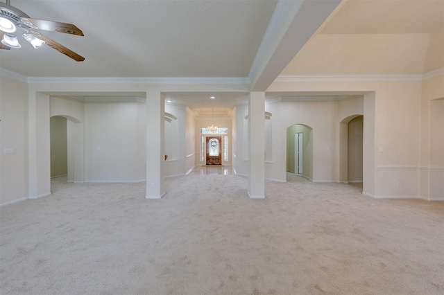 carpeted spare room featuring ornamental molding and ceiling fan with notable chandelier