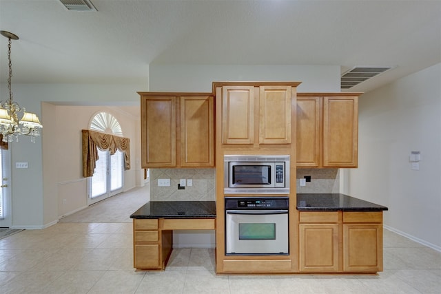 kitchen with stainless steel appliances, decorative light fixtures, dark stone counters, and decorative backsplash