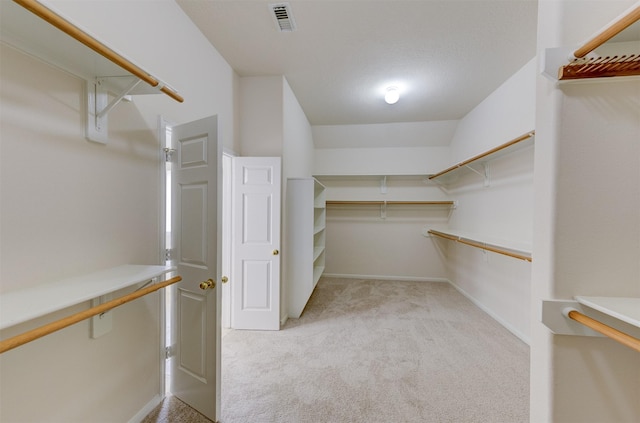 spacious closet featuring light colored carpet