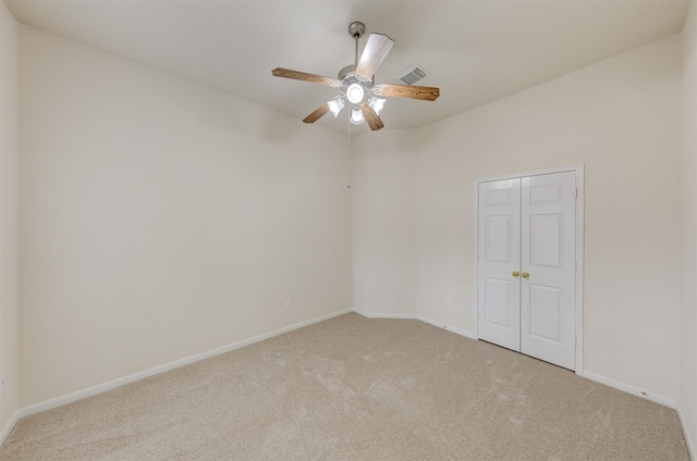 empty room with light colored carpet and ceiling fan