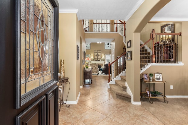 foyer with crown molding and light tile patterned flooring