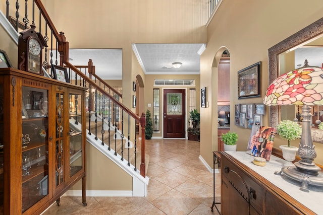 foyer featuring ornamental molding and light tile patterned floors