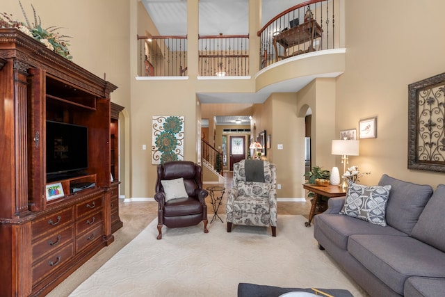 living room with a high ceiling and light colored carpet