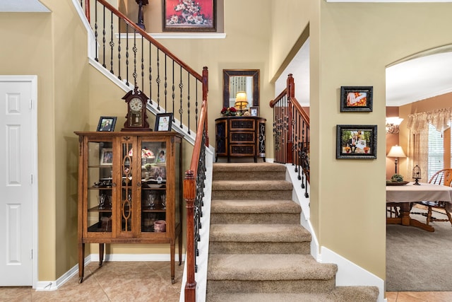 staircase featuring tile patterned flooring and ornamental molding