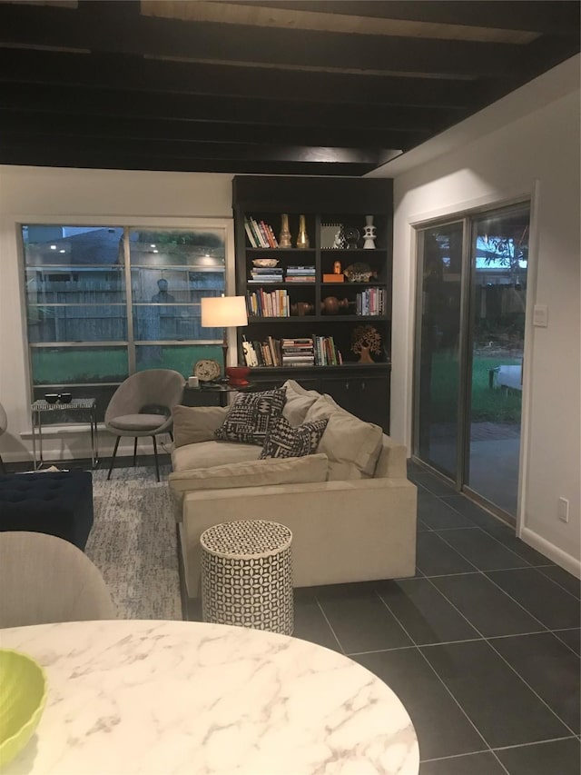 living room featuring beam ceiling and dark tile patterned floors