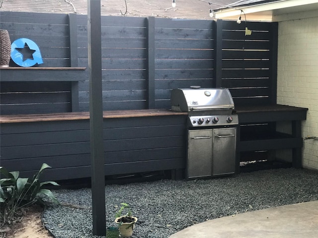 view of patio featuring exterior kitchen and a grill