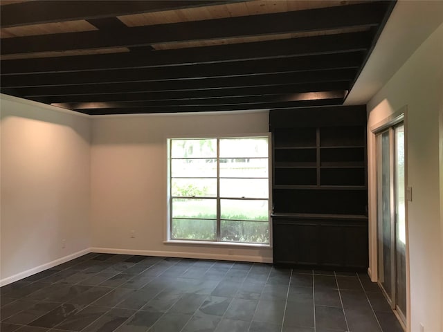 tiled spare room featuring beam ceiling