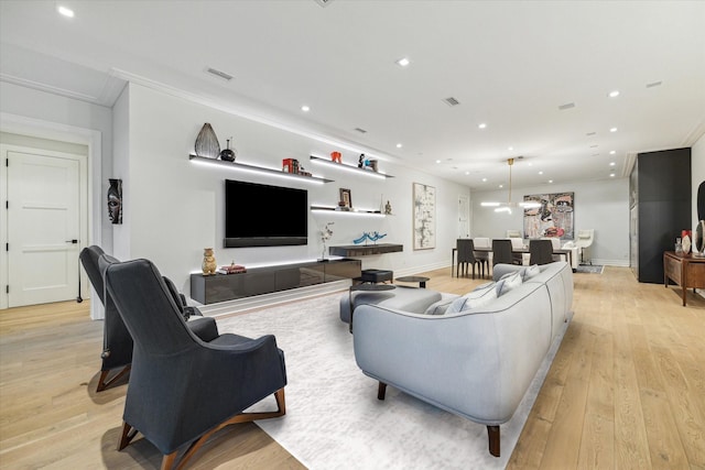 living room featuring light wood-type flooring and crown molding