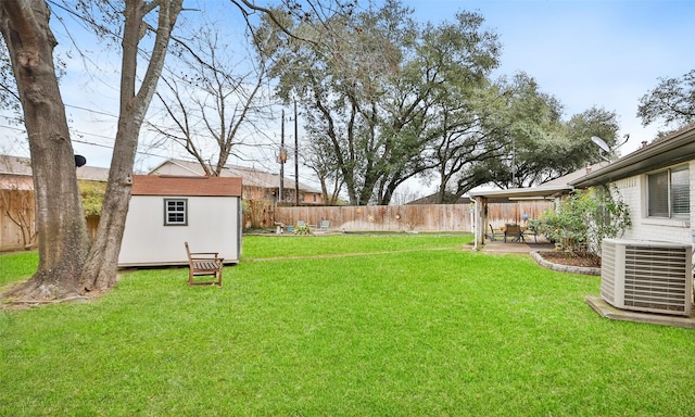 view of yard with central AC unit, a patio area, and a shed