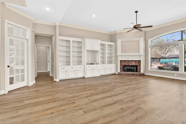 unfurnished living room with ornamental molding, a brick fireplace, and light hardwood / wood-style flooring