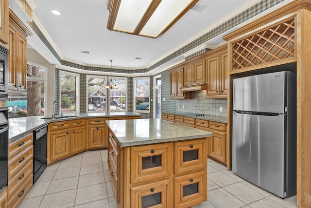 kitchen featuring a kitchen island, decorative light fixtures, black appliances, sink, and kitchen peninsula