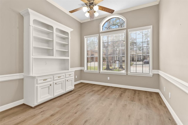 unfurnished dining area with crown molding, ceiling fan, and light hardwood / wood-style flooring