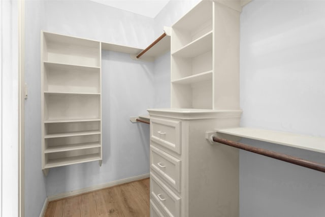 walk in closet with light hardwood / wood-style flooring