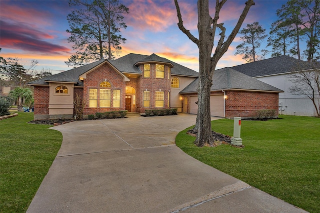 view of front of home with a garage and a lawn