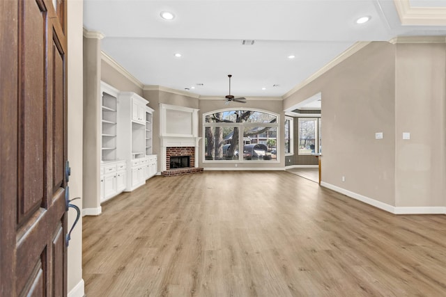 unfurnished living room featuring a brick fireplace, crown molding, and light hardwood / wood-style flooring