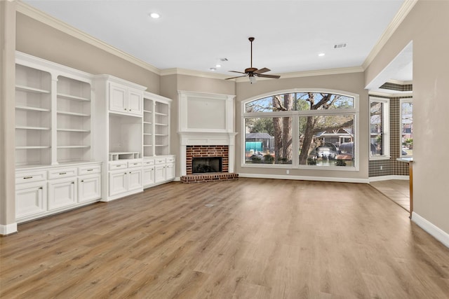 unfurnished living room featuring ornamental molding, plenty of natural light, and light hardwood / wood-style flooring