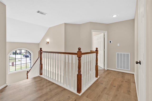 hallway featuring lofted ceiling and light wood-type flooring