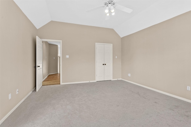 unfurnished bedroom with lofted ceiling, light carpet, a closet, and ceiling fan